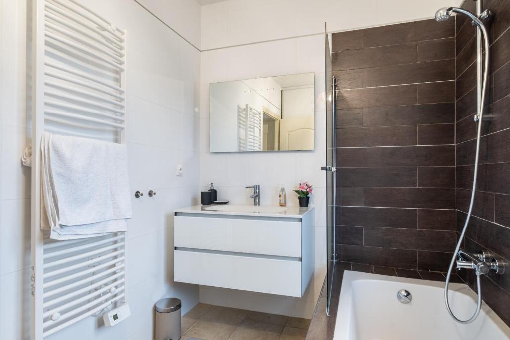 Salle d'eau avec vasque suspendue et paroi de douche