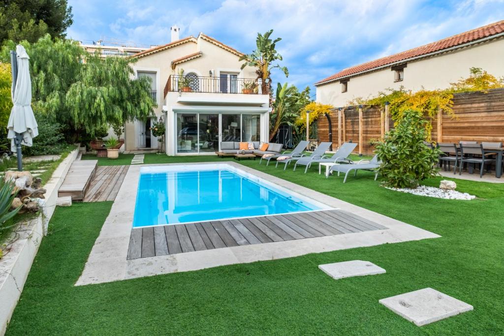 Piscine privée extérieure de la Villa Nelys entourée de terrasses et d'un jardin paysager