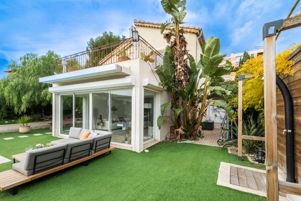 Façade méditerranéenne de la Villa Nelys avec grandes baies vitrées ouvertes sur la terrasse