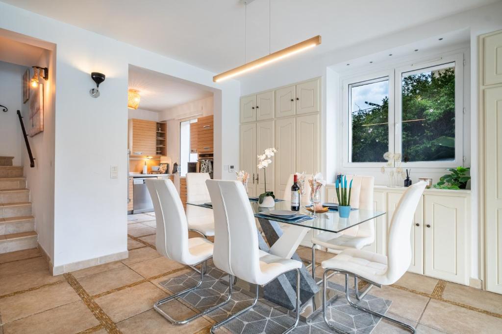 Salle à manger de la Villa Nelys dressée avec chaises blanches