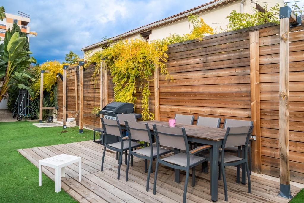 Terrasse en bois de la Villa Nelys avec table repas extérieure sous une pergola