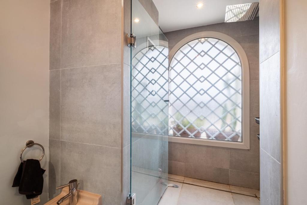Douche à l'italienne avec fenêtre en arche de la Villa Nelys