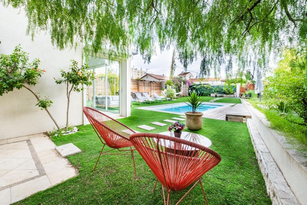 Salon de jardin sous le saule face à la piscine de la Villa Nelys